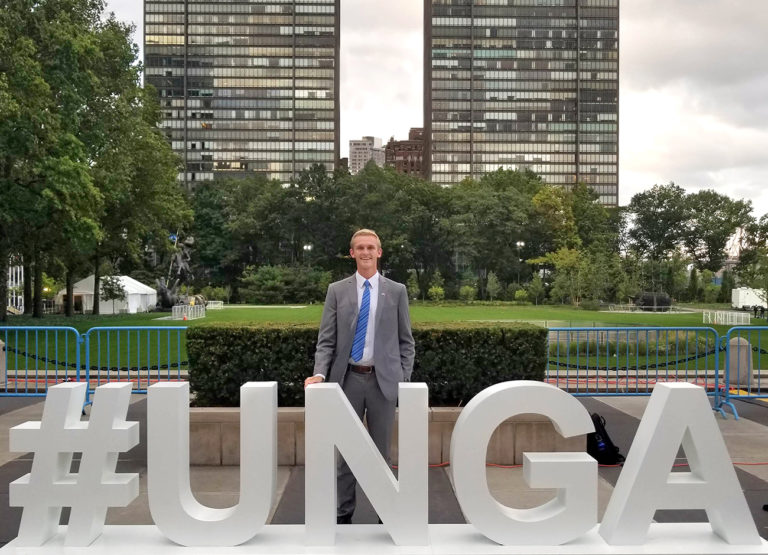 Man standing next to the UNGA sign in New York