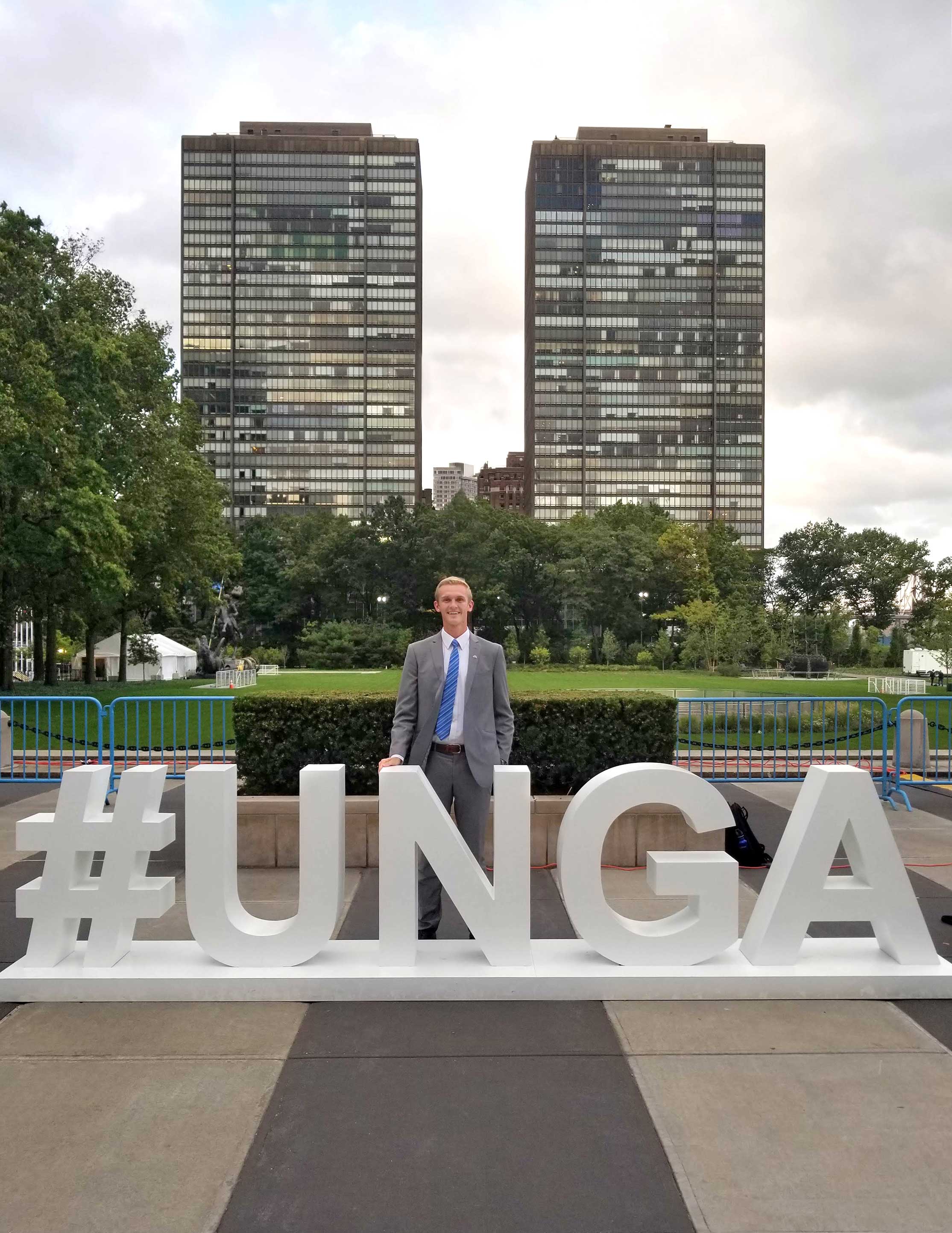 Man standing next to the UNGA sign in New York