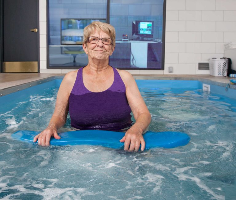 a woman stands in the hydropool for a therapy session.