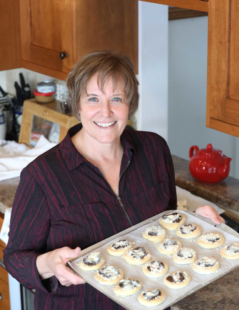 woman holds a tray of kolaches