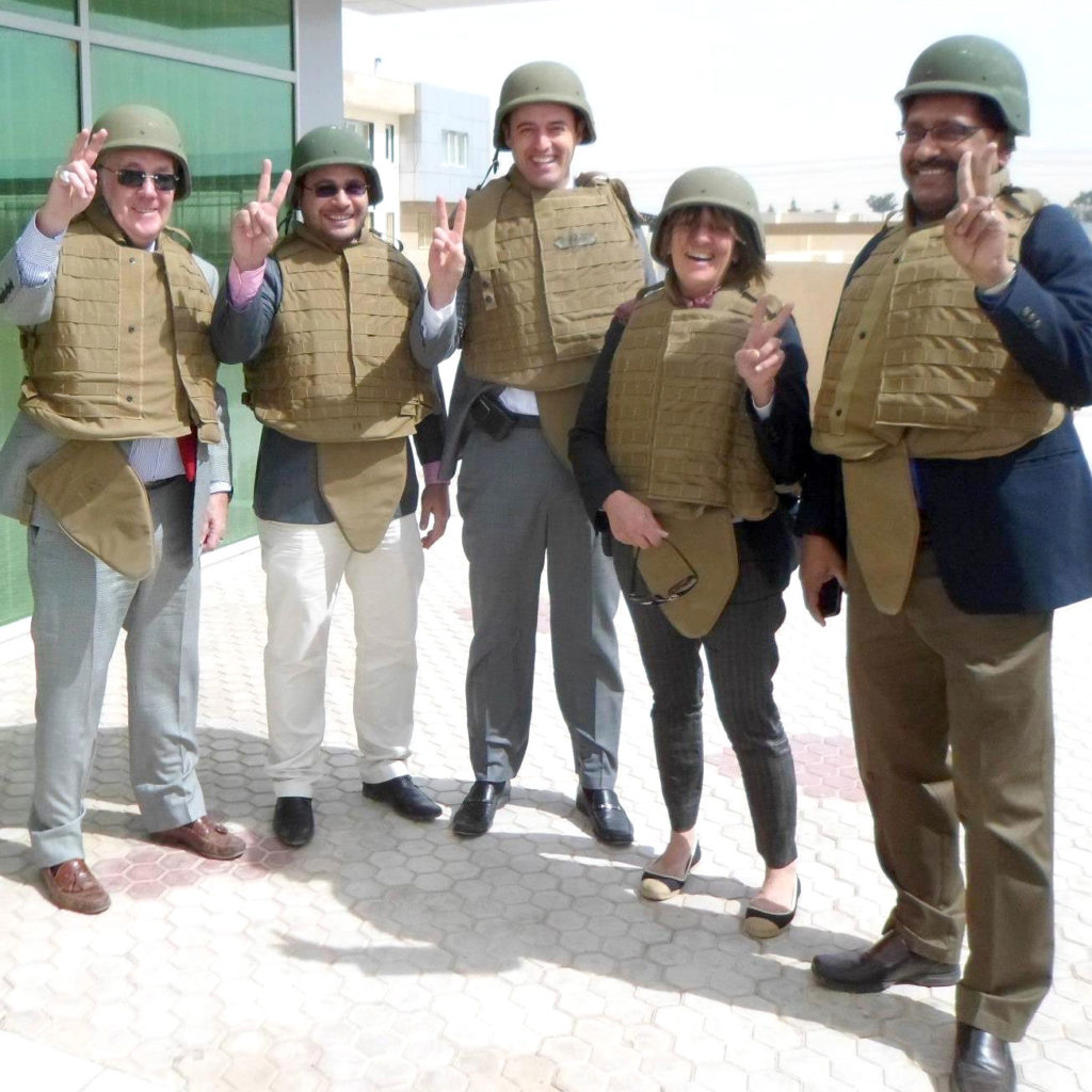 Ben Kolendar stands with a group wearing flak jackets in Afghanistan