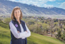 Joyce Kinkead stands on Old Main hill overlooking the snow covered peaks of the valley
