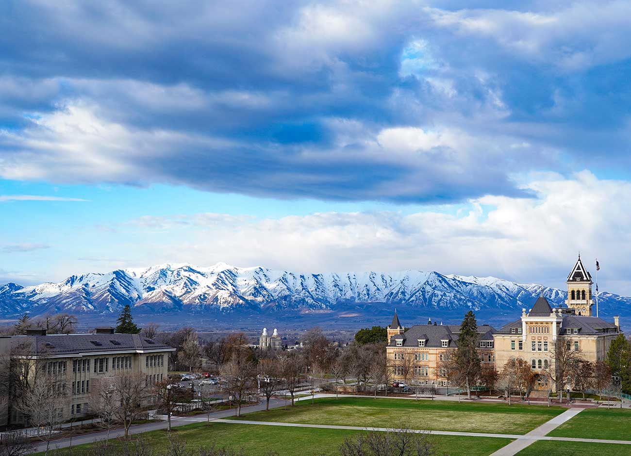 snow-capped mountains flank an empty campus quad.