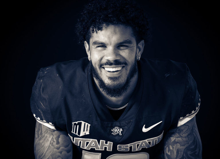 a smiling football player without his helmet