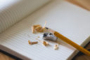 pencil, pencil sharpener and shavings, sit on a blank notebook