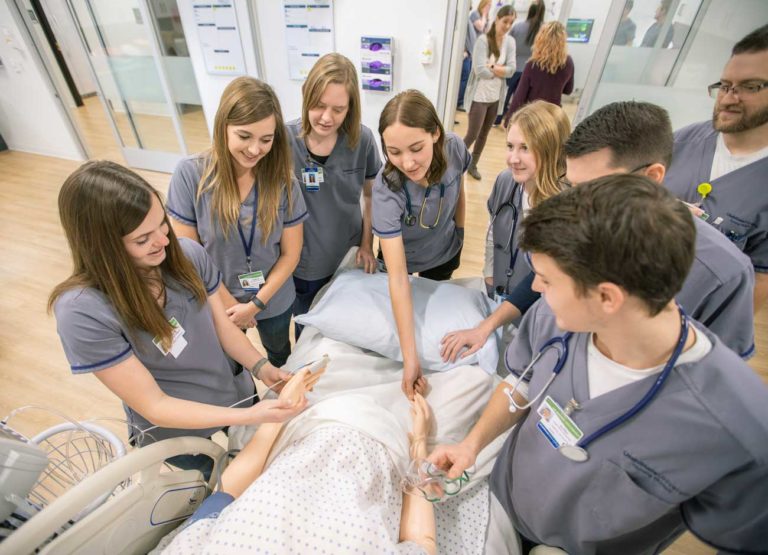 students gather around a mannequin during ther
