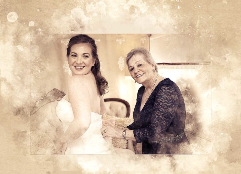 a daughter in a wedding dress poses with her mom who is buttoning the back of her dress