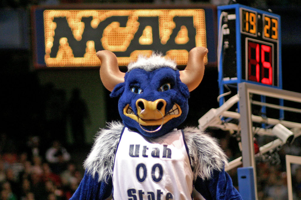 Big Blue wears a basketball singlet with an NCAA sign glowing behind him.