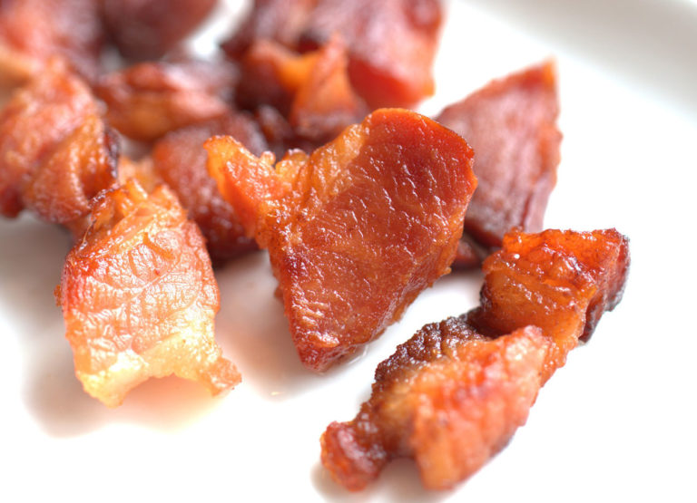 crispy bacon strips on a white plate
