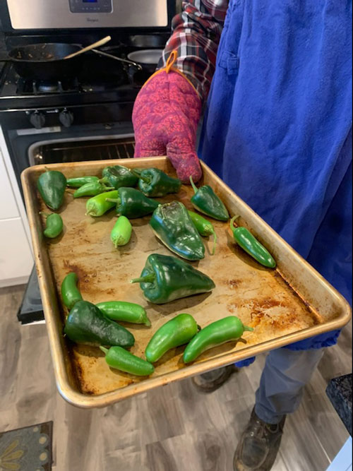 a tray of blistered poblano, serrano, and chili peppers