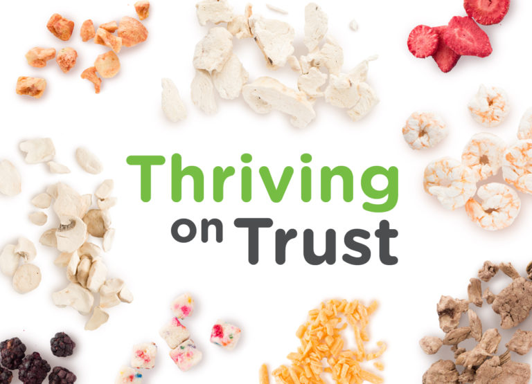 The words: Thriving on Trust surrounded by freeze dried food samples including mushrooms, cheese, confetti cake bites, shrimp, and strawberries