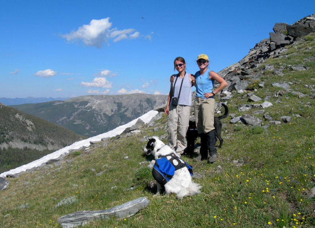 Outdoor mountain scenery with dog and two women.
