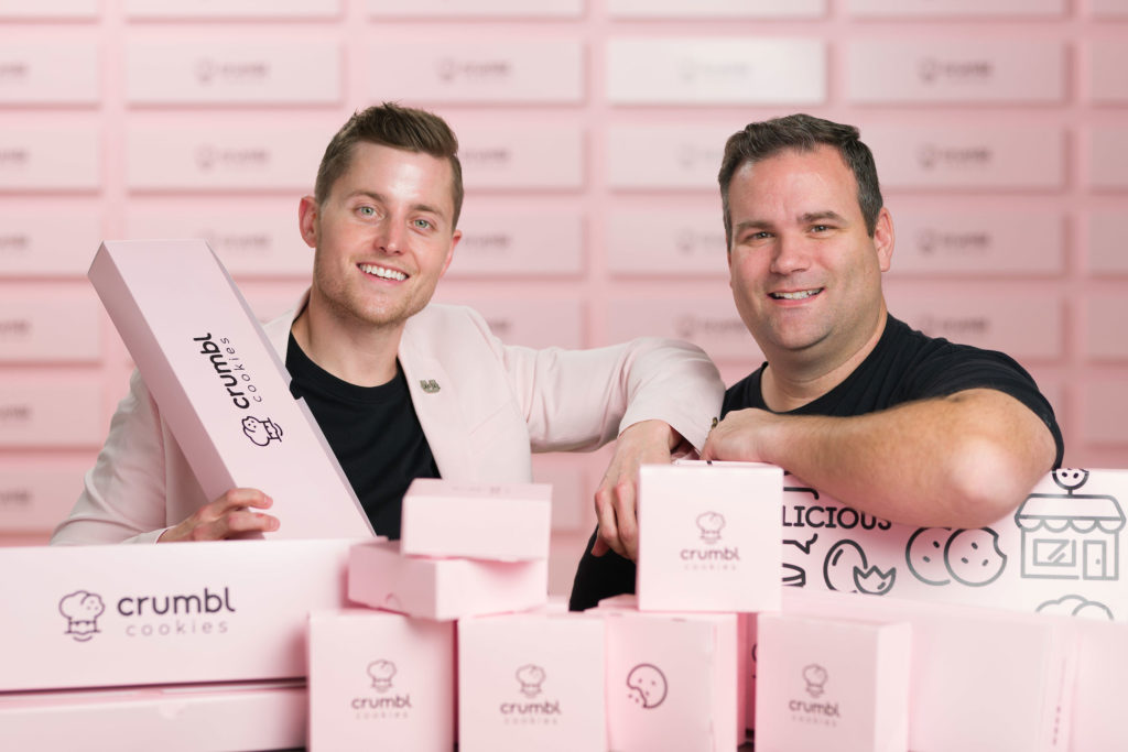 Sawyer Hemsley and Jason McGowan closeup with pink Crumbl cookie boxes