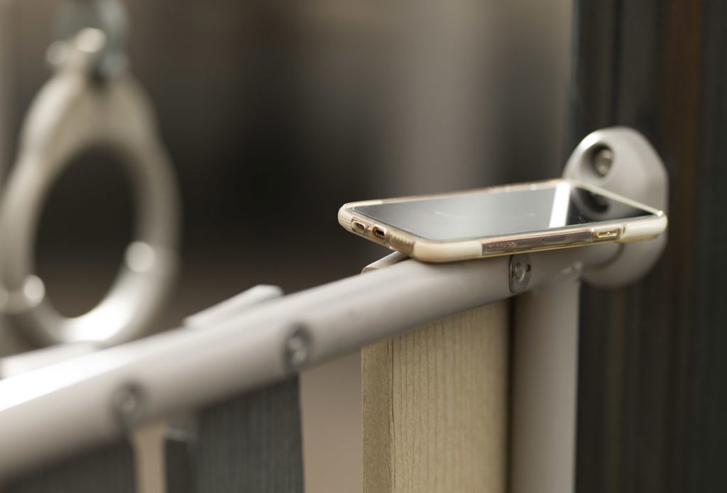a cell phone rests on a playground railing. The background is of monkey bars.