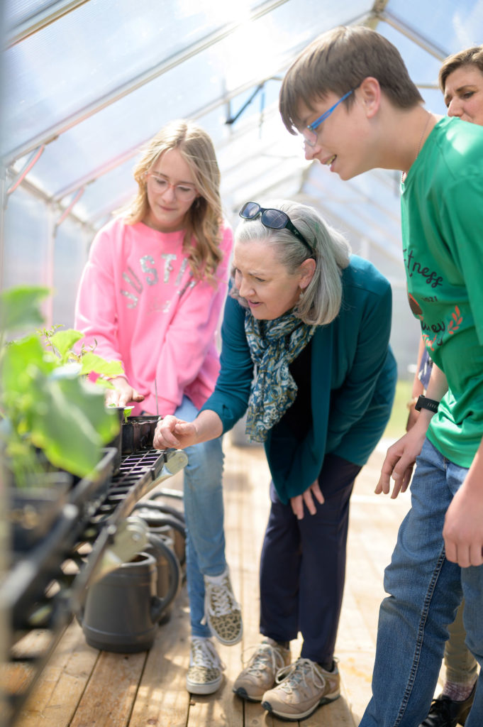 Kathy Trundle and students inspecting plants