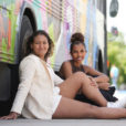 two young women lean against the Utah Black History Museum’s mobile exhibit