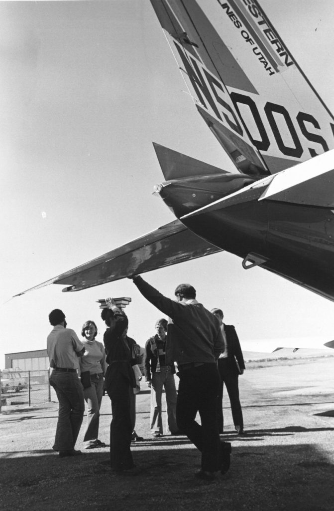 Black and white photo of men near airplane.