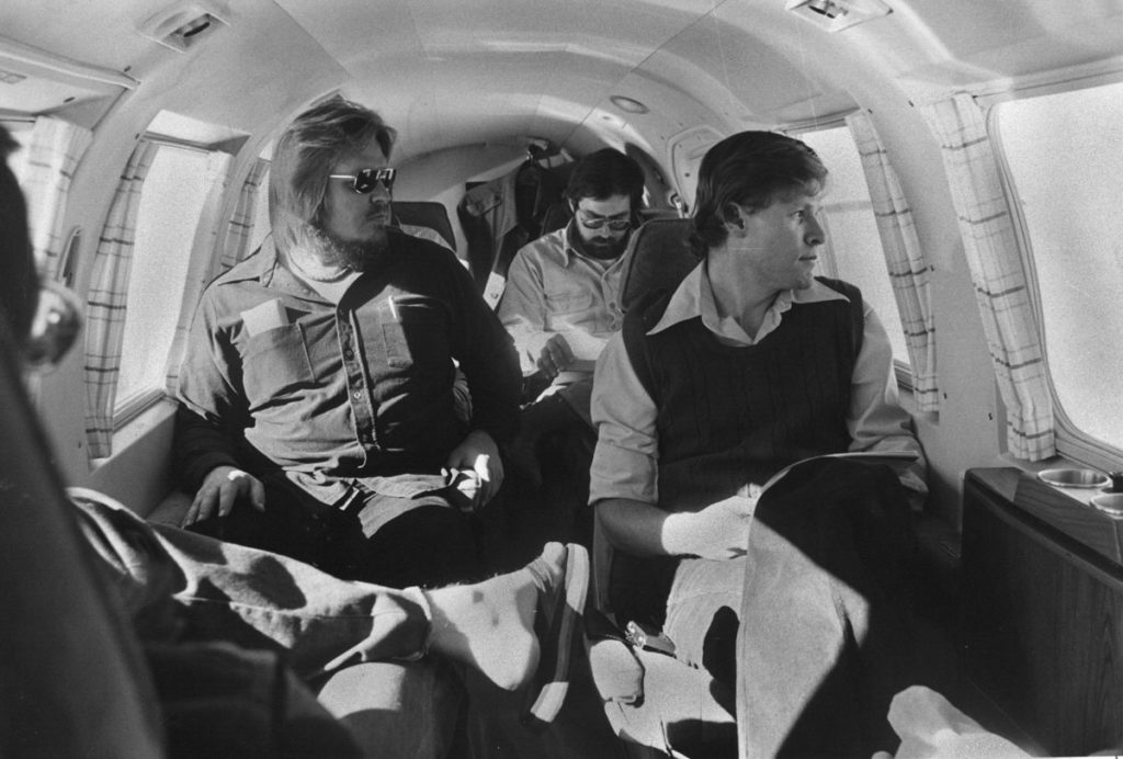 Black and white picture of men on airplane.
