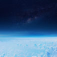 a view of the stratosphere from space. Clouds below, a hazy blue line and then the darkness of space with stars.