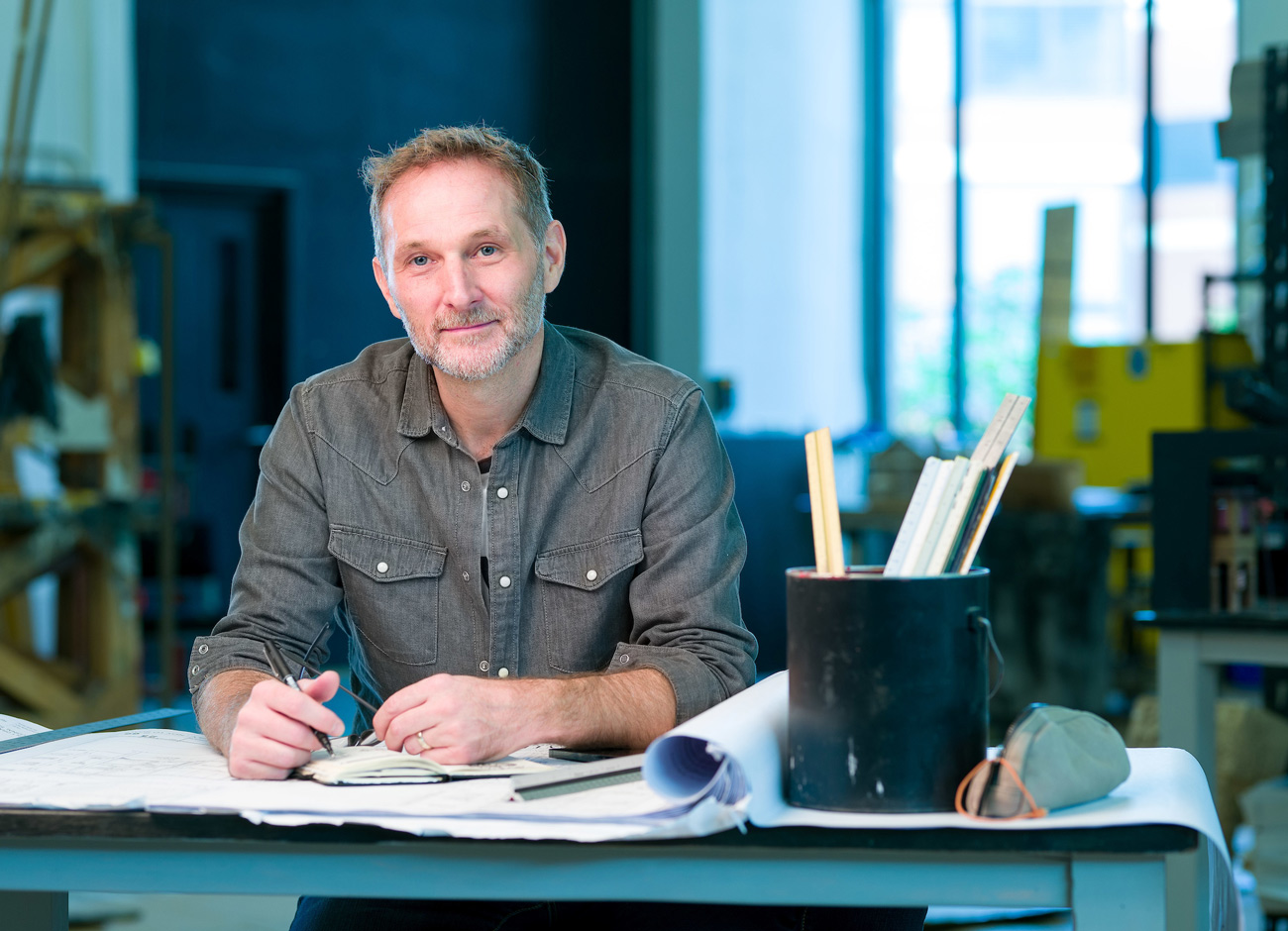 Patrick Larsen of Studio Bound sits a desk with a pen and idea book in hand