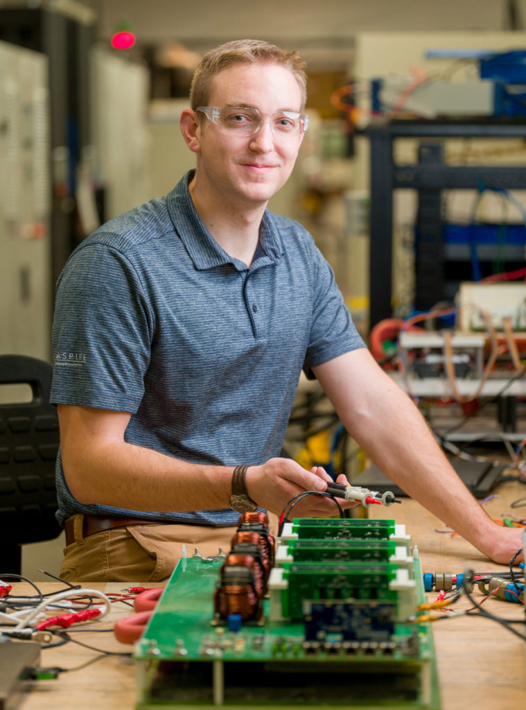 Matthew Hansen holding voltage testers in the lab.