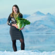 Molly Blakowski stands by the edge of the Great Salt Lake holding a large green cabbage
