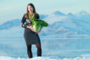 Molly Blakowski stands by the edge of the Great Salt Lake holding a large green cabbage