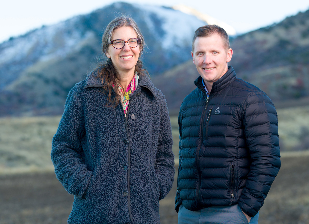professors jennifer reeve and Matt Yost stand in a field discussing carbon farming