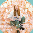 A photo illustration of recent graduate Darcy Ritchie sitting down with a peach and white background comprised of education-related doodles.