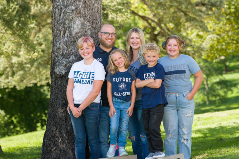 New Utah State magazine editor Tim Olsen poses for a picture with his family on Old Main Hill at USU's campus in Logan.