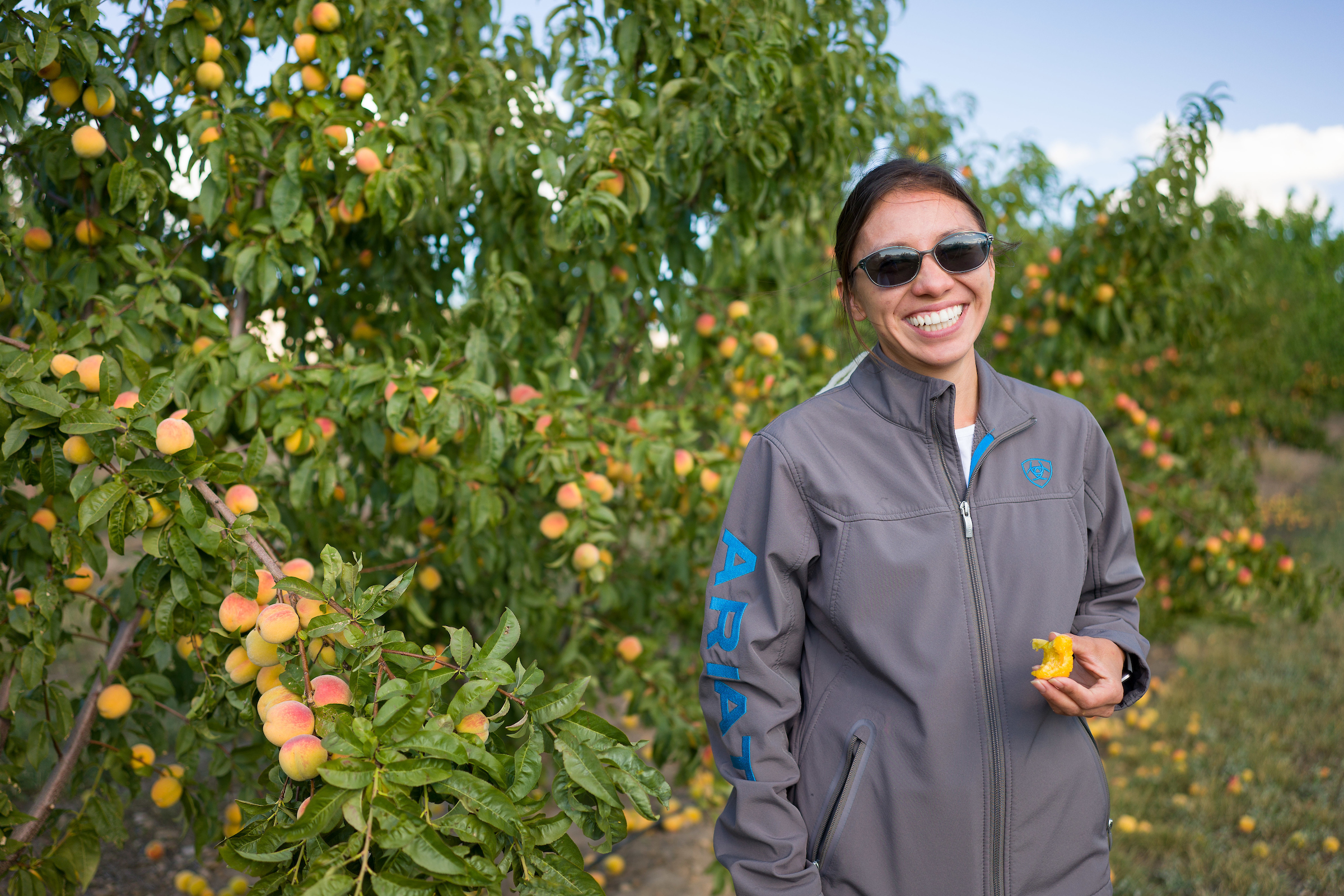 San Juan County Extension agent, Reagan Wytsalucy, poses for a photo in front of one of her Native peach trees.