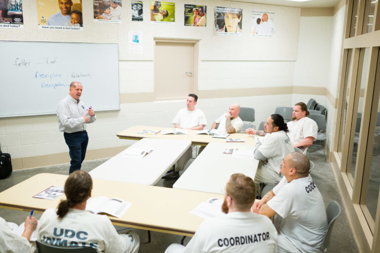 Kelly Kendall, the program director of the InsideOut Dad program teaches the course to a group of incarcerated men.
