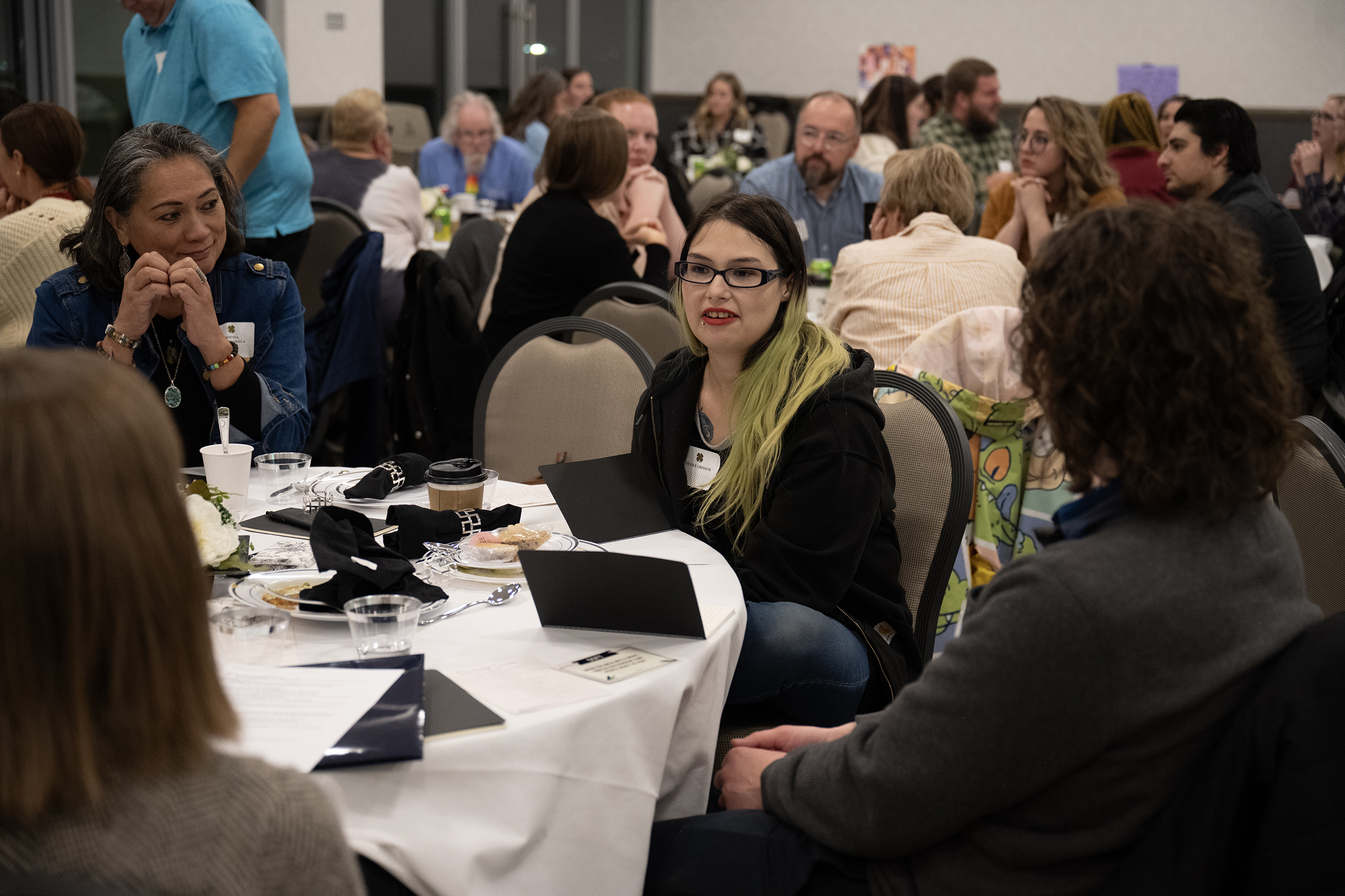 Attendees of Utah State Uintah Basin's Diversity Dinner sit at a round table discussing things prior to dinner.