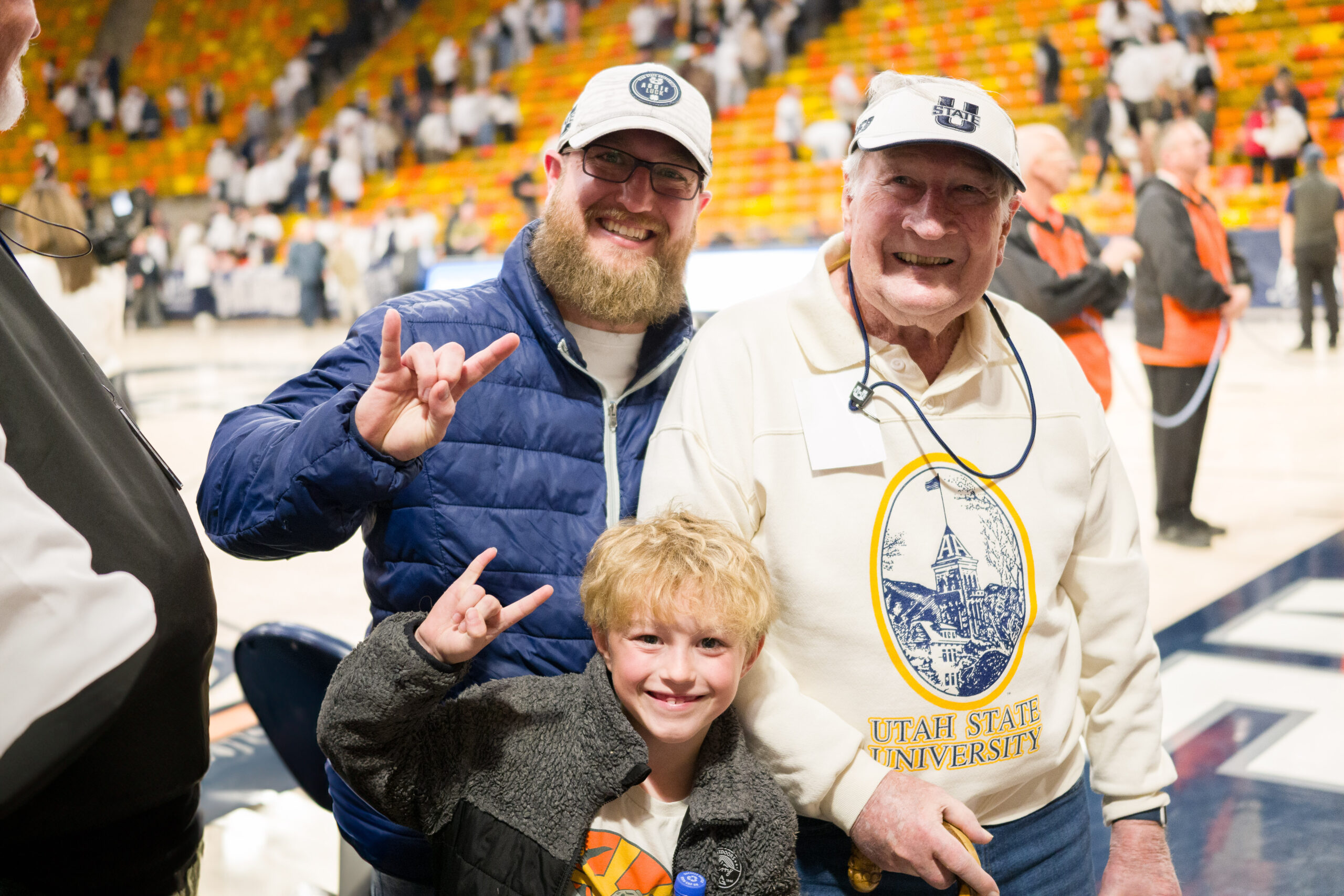 Magazine editor Tim Olsen poses with his grandfather and son after a Utah State men's basketball game.