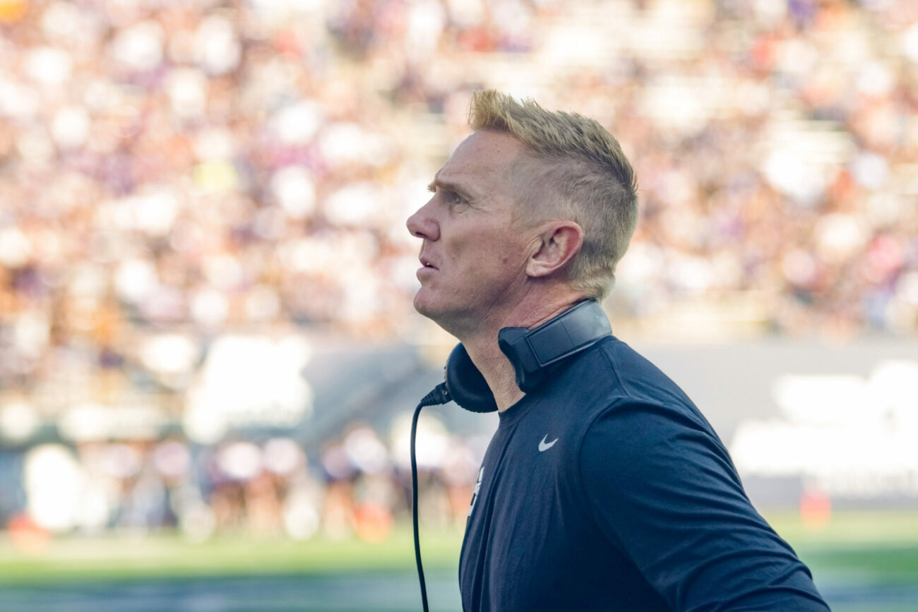 USU head football coach Blake Anderson stands on the sidelines with his headset around his neck during a game at Maverik Stadium.