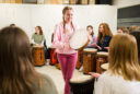 A USU student participates in a drum circle during the music therapy class.